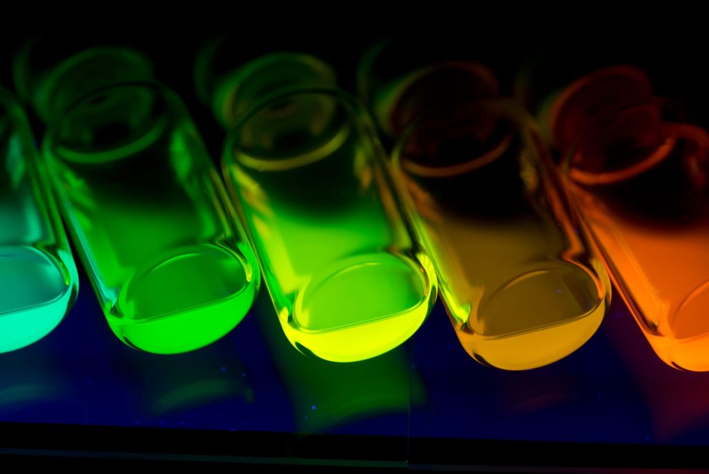 Vials of fluorescent chemicals produced in Syrris Asia flow chemistry systems