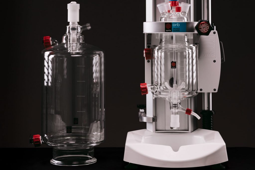 A photograph of an Orb Jacketed Reactor and a spare glass vessel